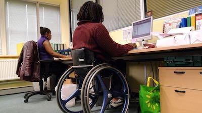 person on a wheelchair working at a desk